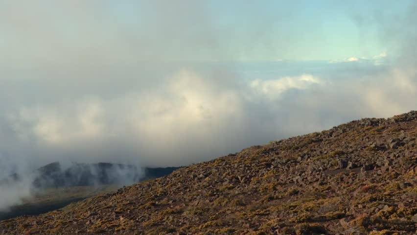 Clouds And Fog Rolling Over Rocky Terrain of Haleakala National Park in Maui, Hawaii. - wide shot