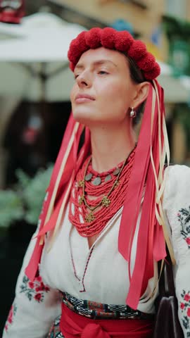 Portrait of a proud Ukrainian woman wearing traditional vyshyvanka, an embroidered shirt, with a striking red wreath and elaborate beaded necklace. Captures beauty and cultural heritage.