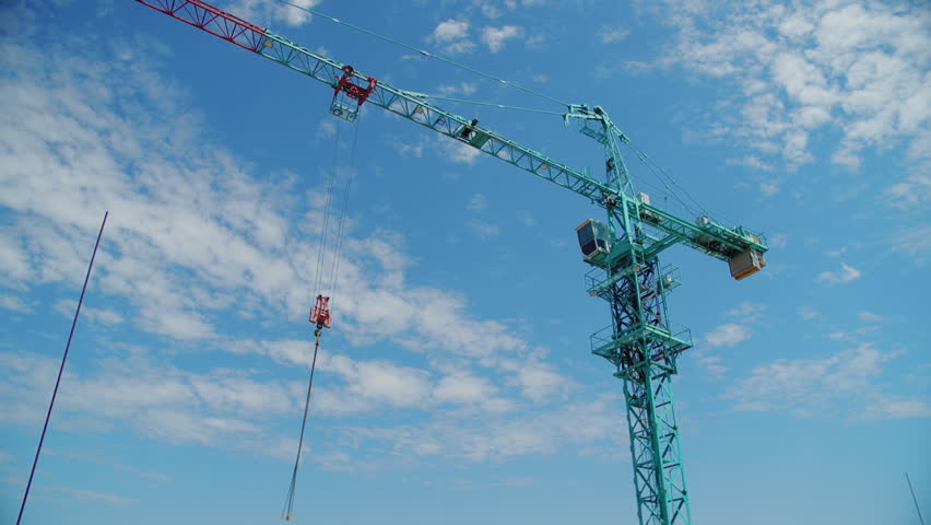 Tower crane against blue sky at construction site