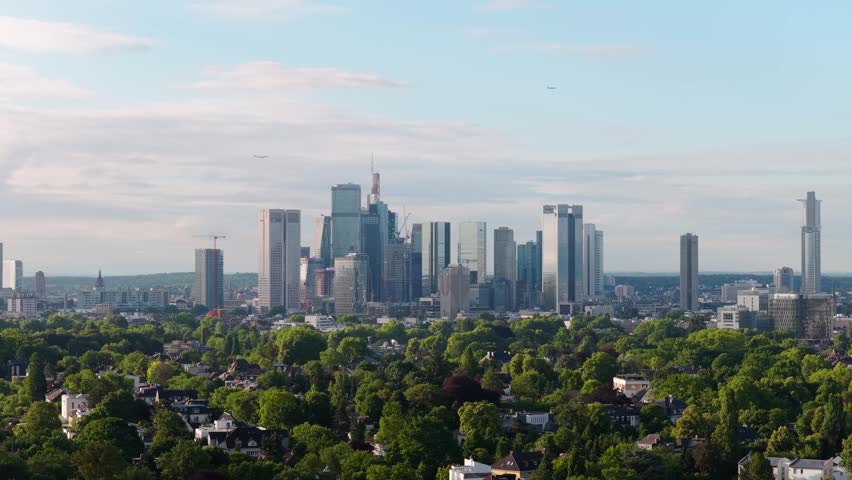 Frankfurt am Main financial district skyline and green cityscape with modern skyscrapers, office towers, residential buildings and flying airplane in Frankfurt, Germany