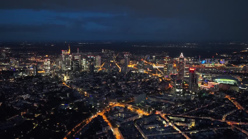 Frankfurt skyline at night with illuminated skyscrapers and urban landscape, high angle panorama showing city lights and financial district of Frankfurt am Main, Germany