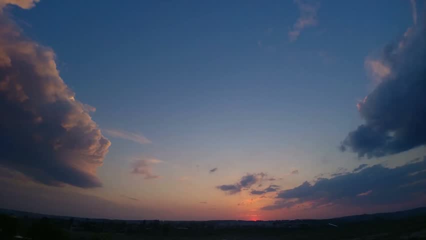 Picturesque sunrise over a cloudy sky in a time-lapse view, capturing shifting light, dramatic clouds, and serene natural beauty.
