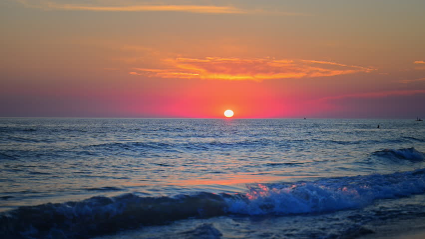 Romantic sunset over the ocean horizon with peaceful water and vivid clouds, cinematic 4K
