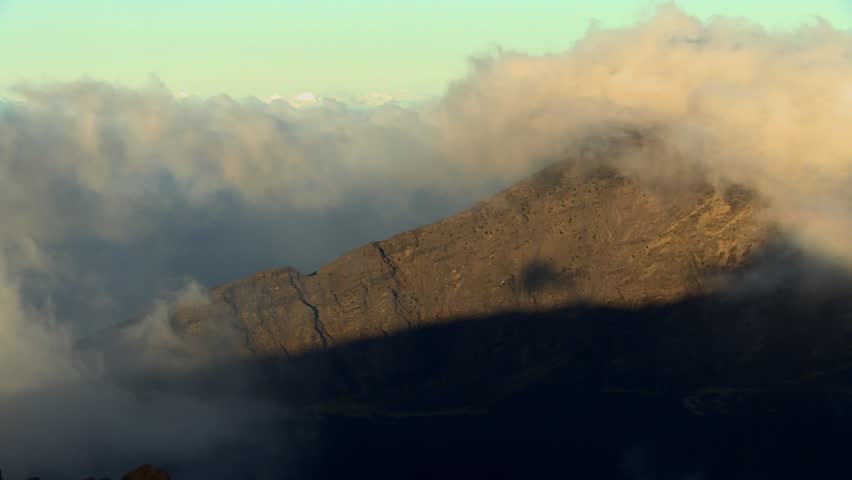 Clouds Moving Over Mountain Range At Sunrise In Haleakala National Park, Hawaii. - wide shot