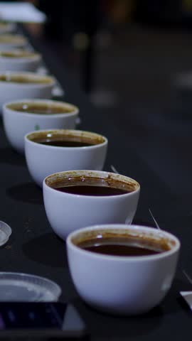 Row of white cups with specialty coffee for a professional cupping and tasting event