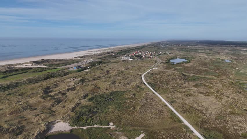 Far distance drone overview of roads dunes lakes hotel and shoreline.