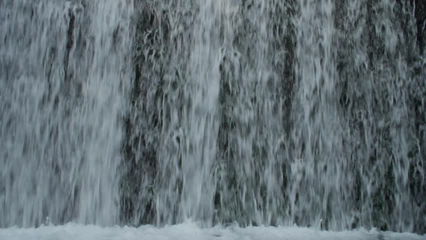 Close backdrop of waterfall curtain with rushing freshwater and textured flow patterns