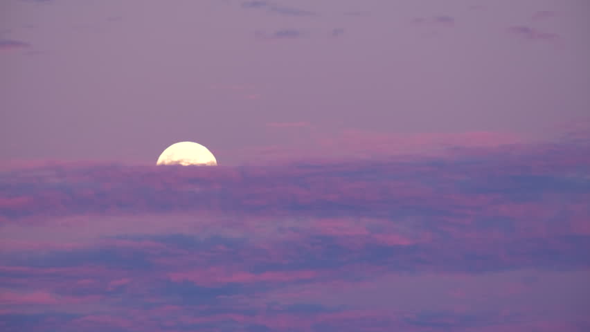 Vibrant twilight sky and clouds with full moon rising, telephoto