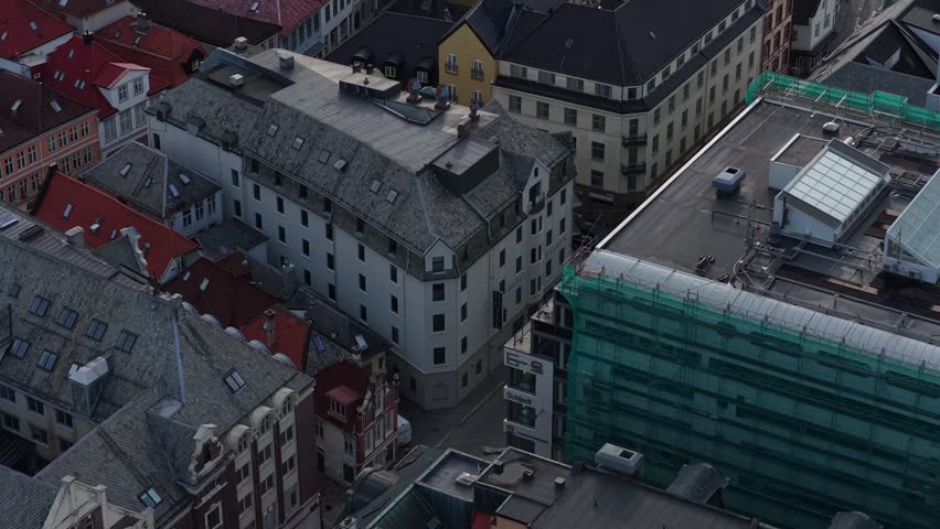 Drone shot reveals a mix of historic and modern rooftops in Bergen city center.