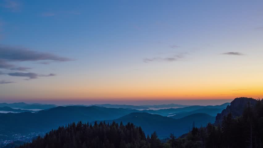 Cloudy weather over hills covered with spruce forests in Rhodope Mountains and fog between mountain ranges