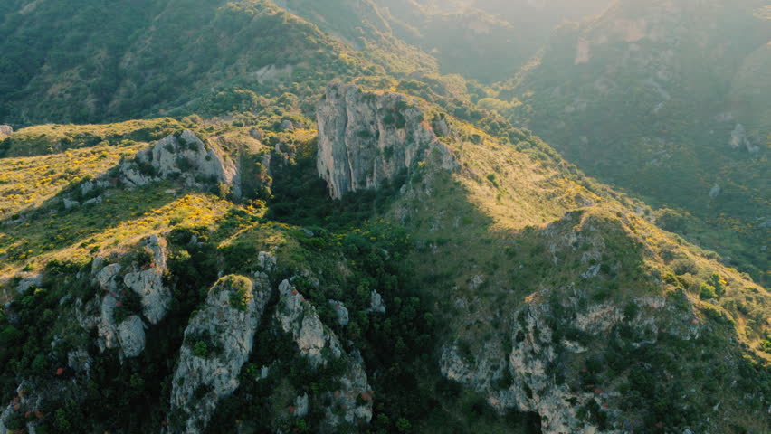 Rocky mountain landscape with sunlit vegetation