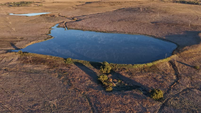 A smooth hyperlapse of a dam in the Free State, capturing the movement of clouds and shifting light across the water and surrounding terrain in a dynamic time-lapse sequence.