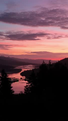 Colorful Sunset Over a Scenic Bay with Illuminated Waterfront and Mountains in British Columbia, Canada
