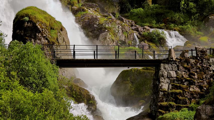 Bridge over the Kleivafossen waterfall on the way to Brikdalsbreen Glacier in Norway.