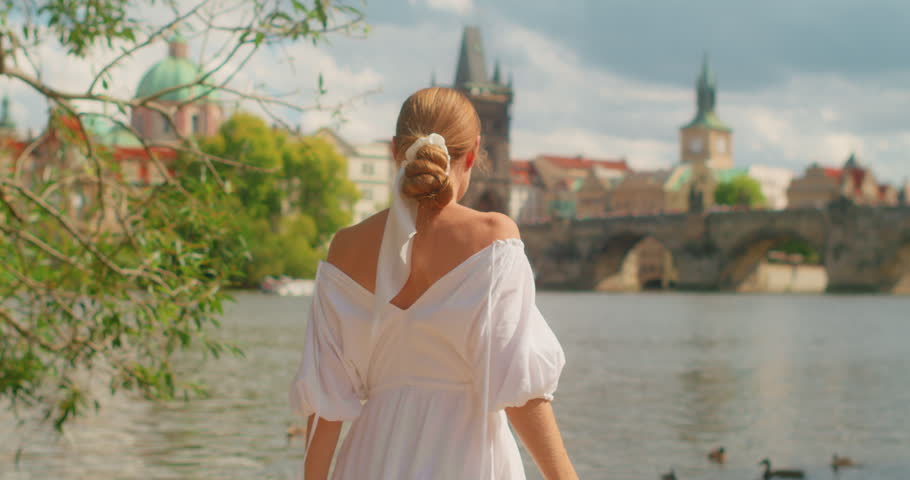 Traveler woman enjoying riverside scenery near Charles Bridge in Prague Czech Republic