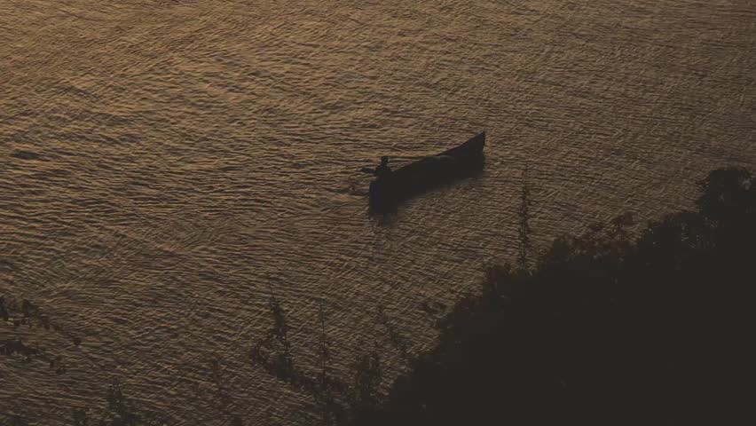 man paddling a small canoe