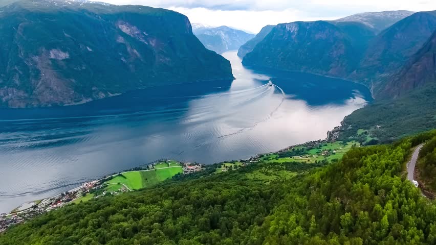 Aerial scenic view of Norwegian fjord and winding mountain road.