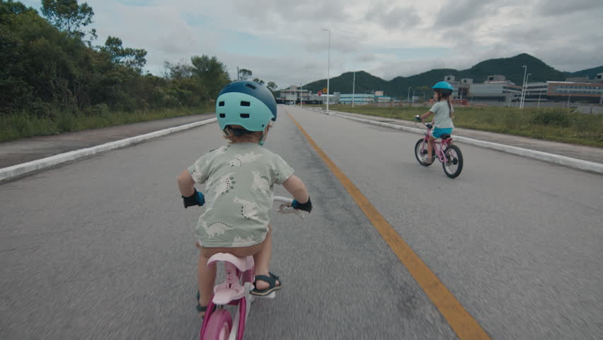 Boy and girl ride bicycles on the safety street with no traffic