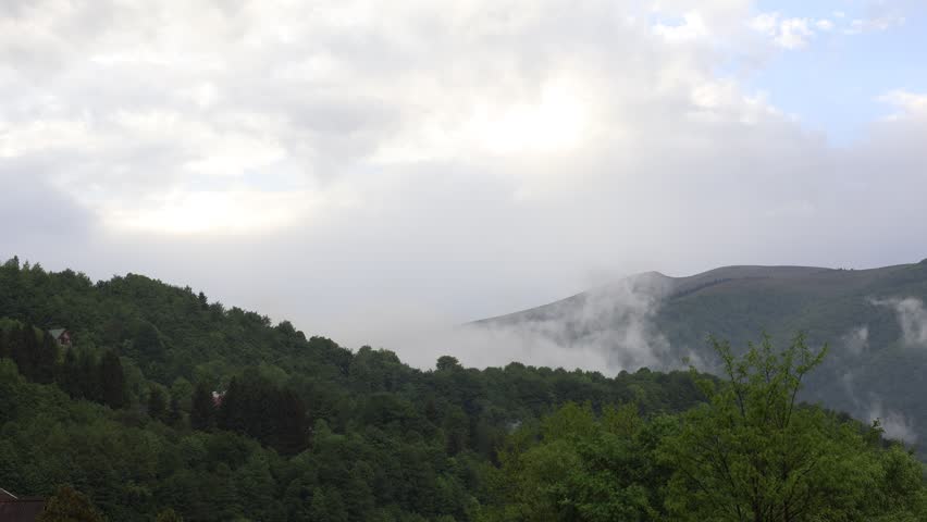 Rising Mist from Forest After Rain in Mountain Landscape with Clouds and Blue Sky.