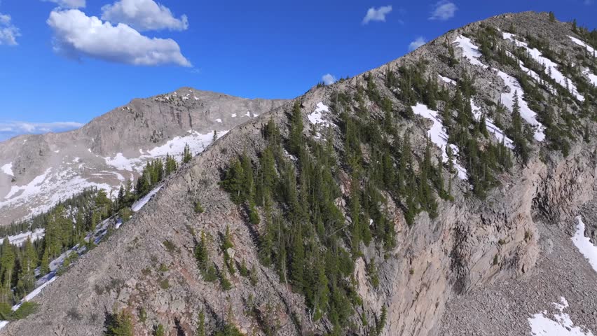 flying over the mountain ridge to revealing a Colorado snowy mountain peak