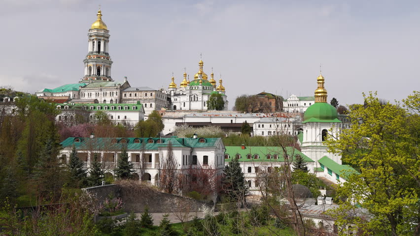 Panoramic view of Kyiv Pechersk Lavra (Kyiv Monastery of the Caves) in spring. Great Lavra Bell Tower, Refectory Church, and beautiful orthodox cathedrals with golden domes on the hills of Kyiv, Ukraine. Scenic cityscape under a bright sky.