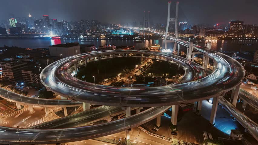 Aerial view captures iconic Shanghai Nanpu Bridge spiral highway interchange at night.