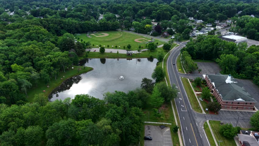 Aerial view of park pond, baseball fields, and nearby road in suburban Massachusetts