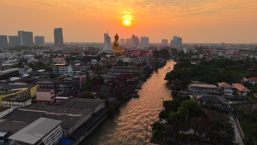 Golden buddha statue at wat paknam phasi charoen sunset sky with rivaer aerial view sightseeing travel in Bangkok Thailand 