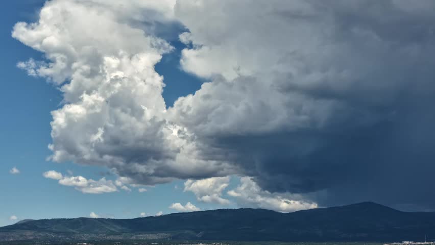 Drone timelapse focusing on rugged mountain peaks as a powerful monsoon storm sweeps across the sky. The intense weather shifts rapidly, showcasing dynamic climate variations.