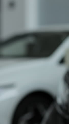 Vertical video Close up woman hand gives a car keys to buyer hand in car dealership close up. Concept of car shopping, buying, and dealership.