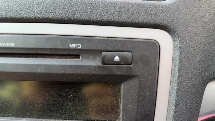 Close up of car stereo CD slot and dashboard media system, in vehicle audio entertainment concept.