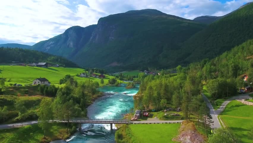 Scenic river flowing through green valley with mountains