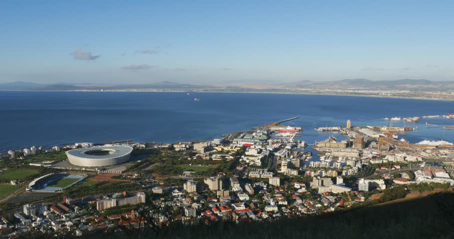 4k 24p panoramic view of Cape Town from Signal Hill, featuring the V and A Waterfront, bustling harbour, Cape Town Stadium and city skyline beneath Table Mountain, Western Cape, South Africa.