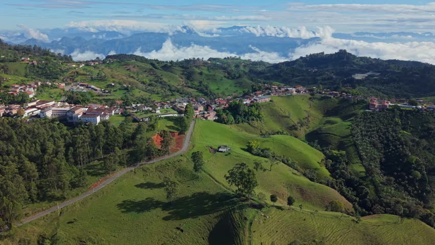 Aerial view of Jerico town nestled in lush green hills with mountain backdrop