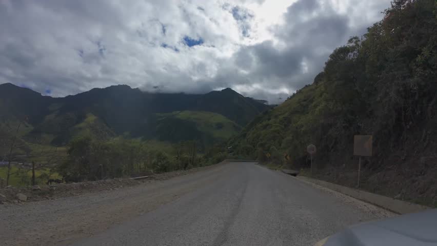 Scenic Andean Mountain Road Through Green Valley Under Dramatic Cloudy Sky In Ecuador