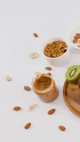Top view of hands placing a nutritious yogurt bowl on a white table with fruit.