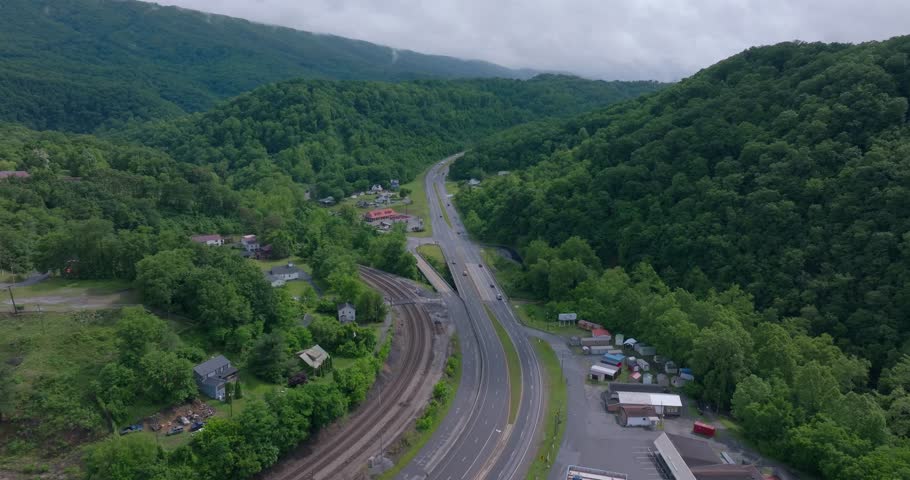 Aerial establishing of highway and rail corridor through Appalachian mountain valley, drone dolly