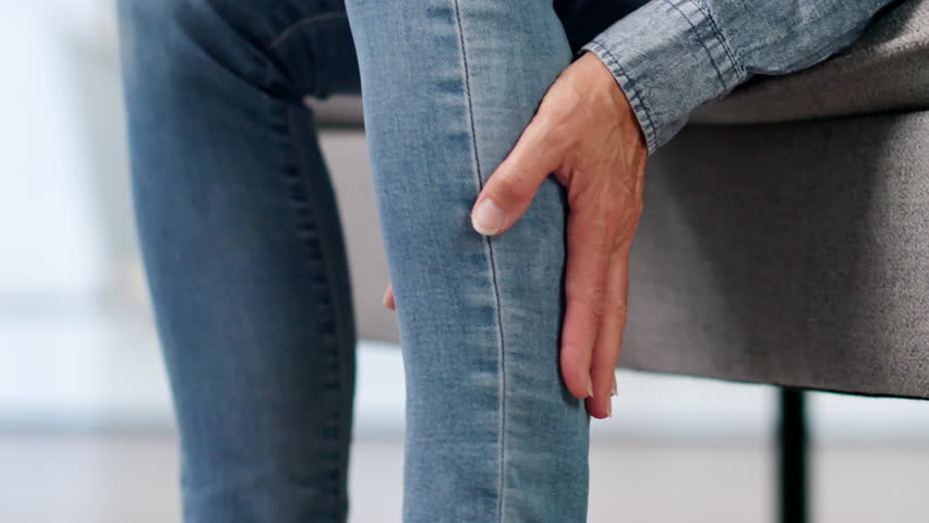 Mature Woman Gently Rubs Leg Easing Muscle Cramp And Swelling Discomfort.