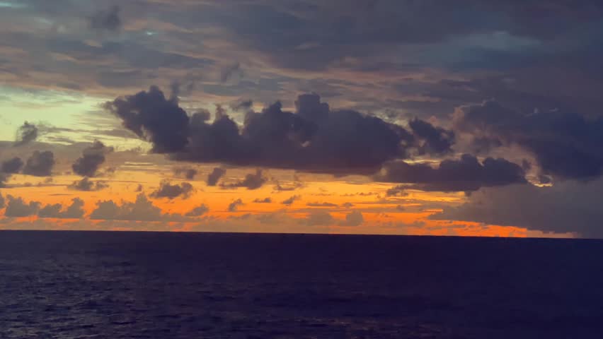 Vibrant sunset with dramatic clouds over a calm ocean