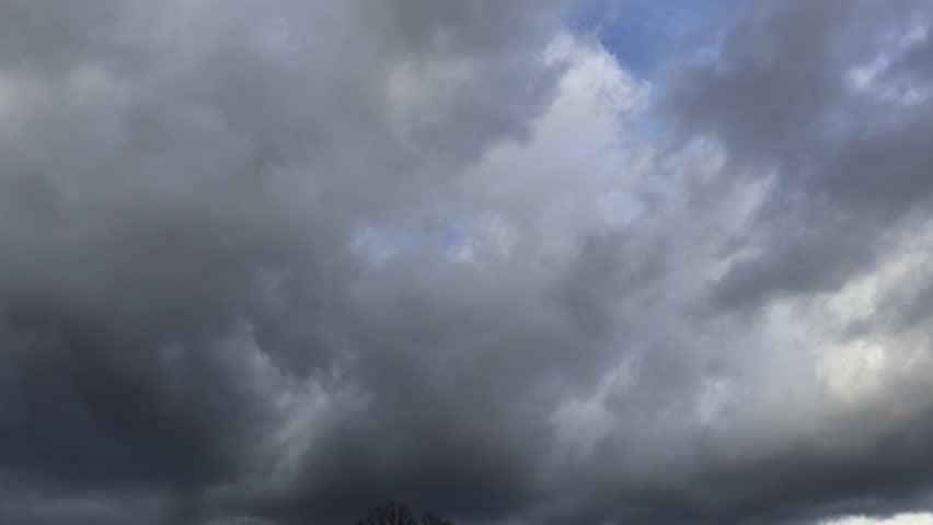 Big clouds drifting over a hill