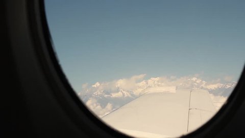 View to the Himalayan mountains from the window in the small local plane in Nepal