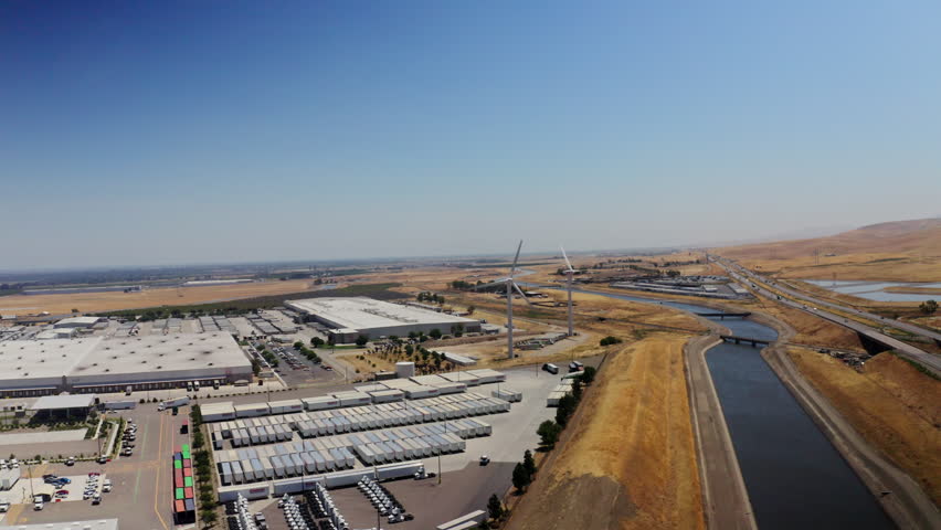 Aerial shot of wind turbines generating electricity and one of the water aqueducts running through California