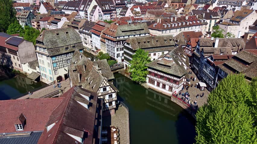 Canal and historic buildings in Strasbourg, France. Aerial backward, cityscape