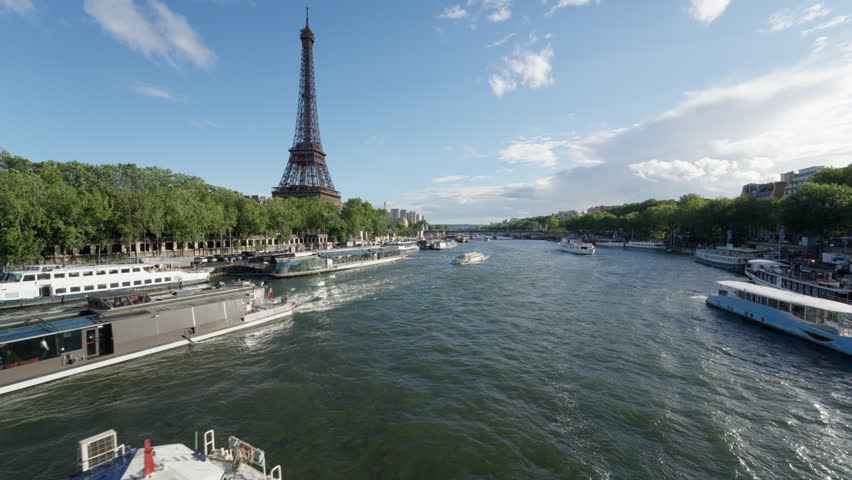 Passenger cruise boats navigate the Seine River near the Eiffel Tower in Paris France during a sunny day. Tourism transport, European travel destination, summer vacation leisure voyage.