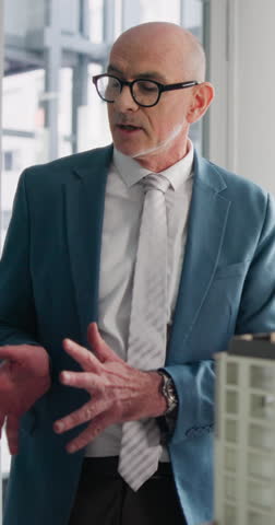 Businessman, realtor or meeting with property model in office for building or infrastructure. Man, employee or real estate agent with 3D apartment or prototype for construction plan or renovation