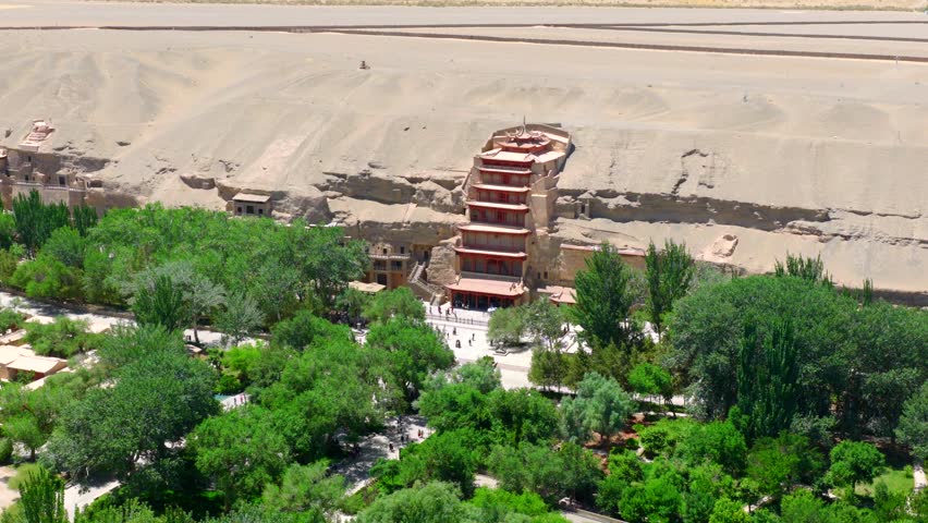 Aerial view of the Mogao Grottoes in Dunhuang, Gansu, China, showcasing the Buddhist statues and murals carved into the caves, and highlighting the art of Chinese murals.
