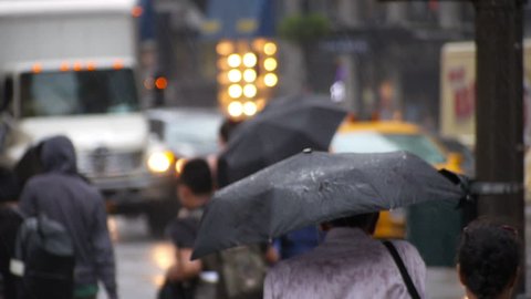 NEW YORK CITY, Circa June, 2013 - Pedestrians with umbrellas try to avoid raindrops on the streets of New York City.
