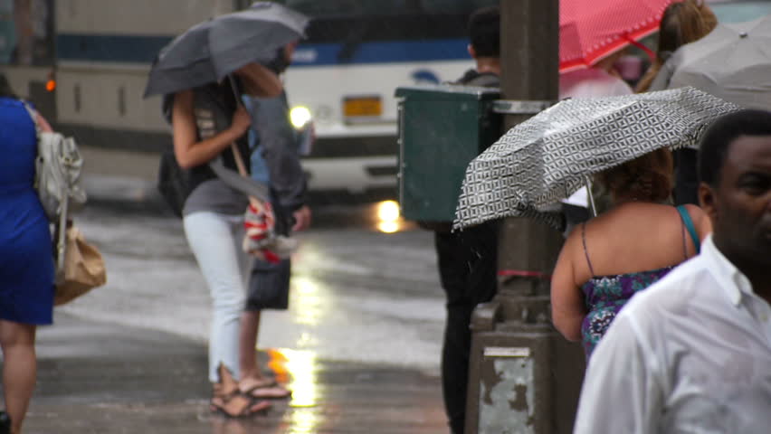NEW YORK CITY, Circa June, 2013 - Pedestrians with umbrellas try to avoid