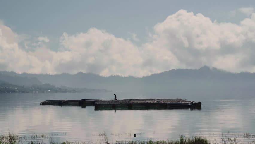 Scenic view of Batur lake. Isolated by cloudy sky. There is fisherman and tilapia fish or ikan mujaer