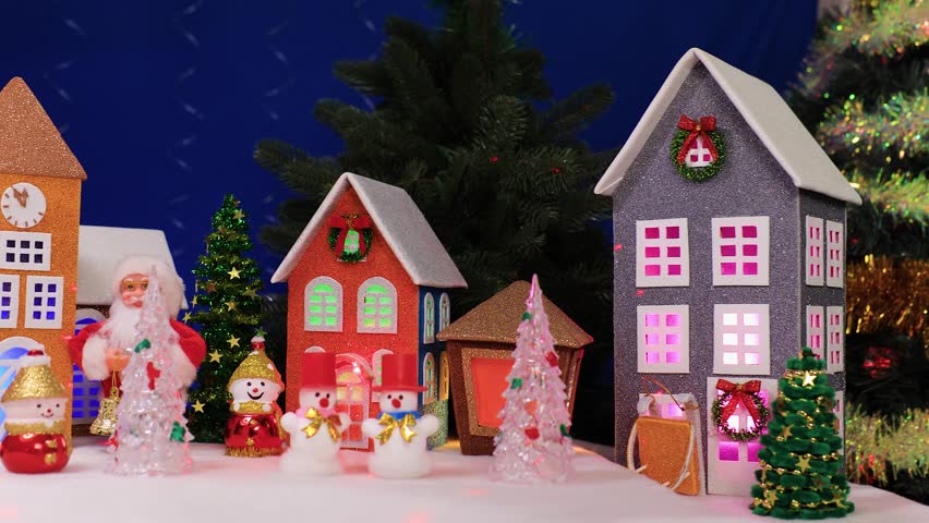 A large Christmas village with colorful houses and Santa Claus holding a Christmas lantern